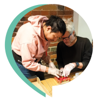 Två män som plockar jordgubbar i en ask